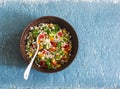 Israeli cous cous ptitim vegetables tabbouleh salad on a blue background, top view. Vegetarian food