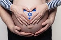 Israeli family concept. Man embracing pregnant woman belly and heart with Israeli flag colors closeup Royalty Free Stock Photo