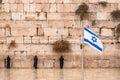 Israeli flag against the western wall on a cloudy day in Jerusalem