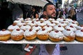 Israeli man carry a baking tray full of fresh Sufganiyot Israeli doughnuts