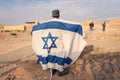 Israeli military infantry stands in middle of the desert holding an Israeli flag with the star of David. Jewish patriot. Military