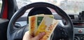 Israeli new shekels banknotes of 100, 50 in female hand inside sport car