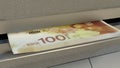 100 Israeli shekels in cash dispenser. Withdrawal of cash from an ATM. ILS. 3d render