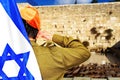 Israeli soldier with Flag of Israel salutes on  background of Western Wall in the Old City of Jerusalem in Israel Royalty Free Stock Photo