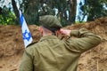 Israeli soldier salutes the flag of Israel on military exercise. Concept: Soldiers IDF