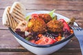 Israeli street food. Falafel salad with hummus, beetroot and vegetables in bowl in a restaurant