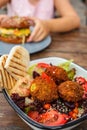 Israeli street food. Falafel salad with hummus, beetroot and vegetables in bowl in a restaurant