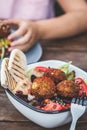 Israeli street food. Falafel salad with hummus, beetroot and vegetables in bowl in a restaurant