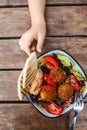 Israeli street food. Falafel salad with hummus, beetroot and vegetables in bowl on wooden background, top view