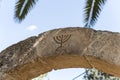 The Israeli symbol - Menorah - carved in stone on an arch at the entrance to the archaeological site of Tel Shilo in Samaria