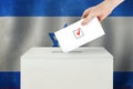 Israeli Vote concept. Voter hand holding ballot paper for election vote on polling station