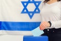 Israeli woman putting a ballot into a voting box on election day.