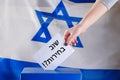 Israeli woman votes at a polling station on election day. Close up of hand. Hebrew text elections again. Royalty Free Stock Photo