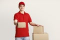 Issuance of parcels at post office. Courier holds out box and puts his hand on stack of parcels
