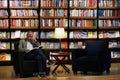 Istanbul, Istiklal Street / Turkey 9.5.2019: Salt Beyoglu Art Center, Men Reading a Book in front of the Bookshelf