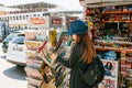 Istanbul, June 17, 2017: Young beautiful girl in a hat with a backpack buys a magazine or newspaper in a street press