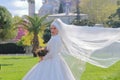 Oriental beauty in a white dress of the bride with a veil fluttering in the wind