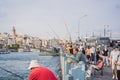 Istanbul, Turkey - August 13, 2022: Local citizens fishing at golden horn on Galata Bridge before sunset with Galata Royalty Free Stock Photo