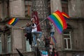 Rainbow flag waiving protestors climb a statue near Istiklal Street, Istanbul during Gay Pride.