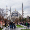 Day shot of Blue Mosque at crowded Sultan Ahmed square at rainy winter day with tourists visiting the place, Istanbul, Turkey