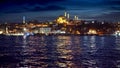 Istanbul, Turkey - February 2023: calm sea waves in Bosphorus reflecting Ayasofya Mosque and illuminated seaside restaurants Royalty Free Stock Photo
