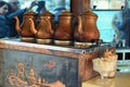 Four old fashioned copper kettles with the tea on the electric stove. Cafe on the deck of a tourist boat. Royalty Free Stock Photo