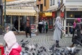 Istanbul Turkey - January 31 2019: A man is advertising restaurant while people feed and catch pigeons.