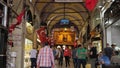 Tourists walk along passage among souvenir shops and stores