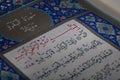 Istanbul, Turkey - June 1, 2018; An open page of Quran shows Surah Al-Baqarah on blue background. Quran is an Islamic holy book