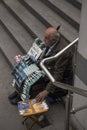 ISTANBUL / TURKEY - 30/05/2015: a lonely old bold Turkish street vendor sitting with his walking stick on the concrete steps by