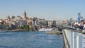 ISTANBUL, TURKEY - MAY, 23, 2019: crowd of fishermen on galata bridge with galata tower in the distance Royalty Free Stock Photo
