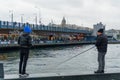 Istanbul, Turkey - 10 May 2023: fishermen are seen fishing with their fishing rod over the iconic Galata Bridge on the Bosphorus.