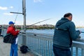 Istanbul, Turkey - 10 May 2023: fishermen are seen fishing with their fishing rod over the iconic Galata Bridge on the Bosphorus.