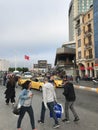 People walking around and cars in traffic at Taksim Square, Istanbul