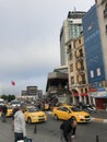 People walking around and cars in traffic at Taksim Square, Istanbul