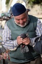 An unknown elderly man holds a pigeon in his hands on a street in Istanbul