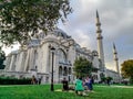 Turkish family resting on the lawn in the Suleymaniye Mosque garden in Istanbul. Old woman