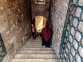 Two Turkish persons walking towards each other in a narrow ancient stone Passageway in