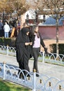 Unidentified Religious Girl with Black Burka walking with her friend at Sultanahmet Square in Istanbul