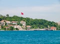 Istanbul / Turkey - Turkish flag, ship and residential buildings at Bosporus strait coast. Photo taken from cruise ship