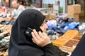 Istanbul Turkey. Veiled woman speaking at the phone at the Street Market in Fatih District