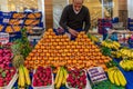 Istanbul, Turkey 11/19/2019 View of a market vendor with a stall full of fresh fruit, he is busy displaying the oranges on a high