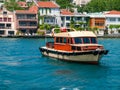 Istanbul, Turkey, Vintage look vessel yacht at Bosporus strait. Residential mansion buildings at coast in the background