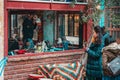 23.12.2019, Istanbul, Turkey. Women stand on the street and take pictures of the cat in a cafe, through the window Royalty Free Stock Photo