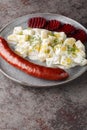 Isterband sausage with potatoes in cream sauce with dill and boiled beets close-up on a plate. vertical Royalty Free Stock Photo