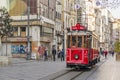 Touristy red nostalgic tram on istiklal street between modern and historical buildings