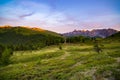 The Italian Alps at sunset. Summer colorful sky over the majestic mountain peaks, woodland and green valleys. Royalty Free Stock Photo