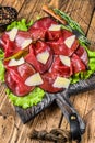 Italian Antipasti Bresaola meat cut with green salad and Parmesan. wooden background. Top view Royalty Free Stock Photo