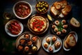 Italian antipasti food selection over dark rustic background. Top view.