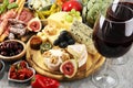 Italian antipasti wine snacks set. Cheese variety, Mediterranean olives, crudo, Prosciutto di Parma, salami and wine in glasses Royalty Free Stock Photo